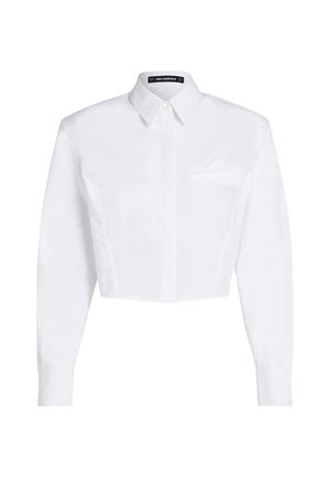 Balts īsais pogājamais krekls ar garām piedurknēm, norādītu apkakli un mazu kabatu kreisajā krūtīs.