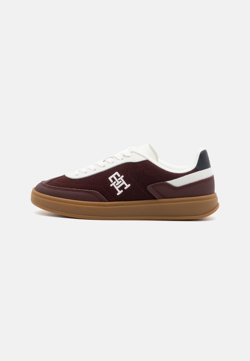 Burgundska suede tenisica s bijelim jezikom, logom sa strane i gumiranim đonom. Sadrži mornarske naglaske na peti.