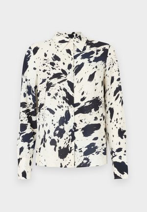 Kreemivärviline särgipluus pikkade varrukatega, millel on suur musta värvi plahvatusmuster. Omab teravat kraed ja eest nööbitavat sulgemist. Lõuendine sile kangas.