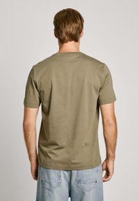 Olijfgroene t-shirt met korte mouwen en een ronde hals, gemaakt van zacht katoen, met een eenvoudig, onopgesmukt ontwerp.