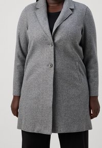 Szary płaszcz wełniany z długimi rękawami, z klapami i zapięciem na dwa guziki; posiada boczne kieszenie i lekko dopasowany krój.