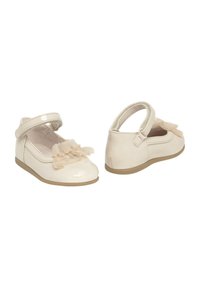 Zapatos de charol en crema clara con un acabado suave, que cuentan con un lazo decorativo de tul y un diseño de correa de velcro seguro. Suela sutil.