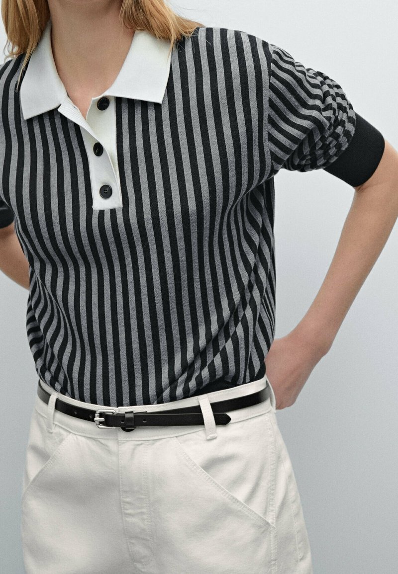 Striped polo shirt in black and gray with a white collar and three black buttons. Paired with white trousers and a black belt.