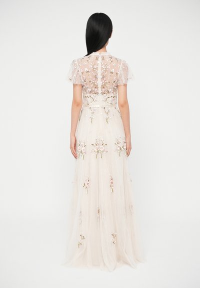 Dlhé maslovobiele šaty s priehľadným vyšívaným živôtikom, kvetinovými vzormi a nadýchanými rukávmi. Splývavá sukňa z textúrovaného materiálu.