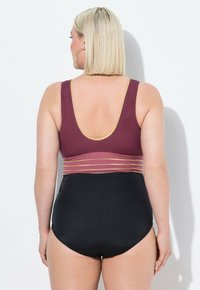 Maillot de bain de maternité avec un haut bordeaux et des accents dorés, associé à un bas taille haute noir, conçu pour le confort et la couverture.