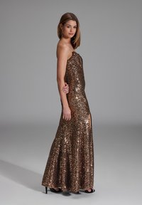 Vestido sin tirantes, de largo hasta el suelo, cubierto de lentejuelas bronce, con una abertura lateral y un corsé ajustado, acentuado por una falda acampanada.