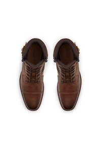 Bruna läderstövlar med snördesign, dragkedjestängning, vadderad krage och kontrasterande sömmar. Slät yta med metallaccentdetalj.