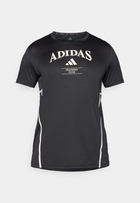 Black Adidas training shirt with short sleeves, featuring white logo text and side accents. Smooth texture and athletic fit.