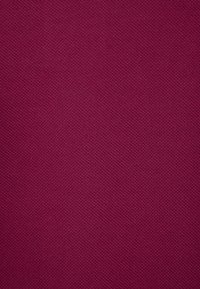 Tejido texturizado en un color burdeos profundo, con un patrón liso y tejido, adecuado para aplicaciones de tapicería o ropa.
