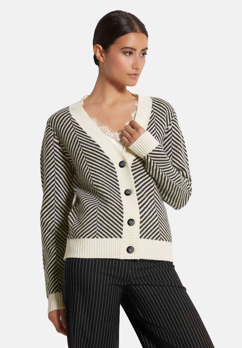 Schwarz-weißer gestreifter Cardigan mit V-Ausschnitt, gerippten Bündchen und fünf Knöpfen. Das Design zeichnet sich durch ein Fischgrätmuster und einen cremefarbenen Saum aus.