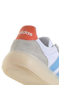 Sko med ovandel i vitt läder, blå ränder, grå mockahäl och en orange läderlapp. Inkluderar en genomskinlig gummisula med ett greppmönster.