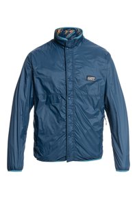 Chaqueta ligera de color azul marino con cierre de botones a presión en la parte delantera, cuello alto y dos bolsillos laterales. El interior presenta un forro con un patrón azul y marrón.