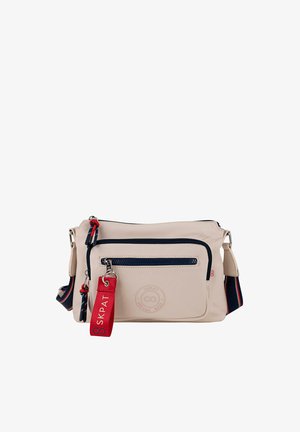 Bolso beige de hombro hecho de material sintético, con cremallera azul marino, un bolsillo frontal y una etiqueta de marca roja. Correa ajustable con detalles en azul marino y rojo.