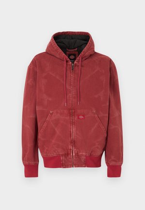 Κόκκινο μπουφάν με κουκούλα και υφή, κλείσιμο με φερμουάρ, τσέπες μπροστά και ριμπ μανσέτες. Μαύρη φόδρα και μικρή ετικέτα με λογότυπο μπροστά.