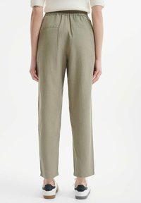 Khaki linnen broek met een elastische tailleband en achterzakken, voorzien van een recht gesneden pijp en een lichte textuur.