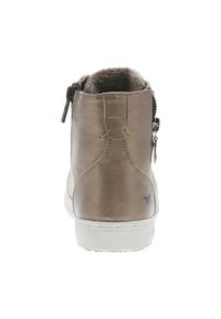 Bottine en cuir marron avec une texture lisse, semelle en caoutchouc blanc, fermeture éclaire sur le côté et doublure en fausse fourrure visible à l'ouverture.