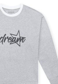 Grijze sweatshirt met lange mouwen, een witte ribbelrand bij de ronde hals, voorzien van zwarte scripttekst "dream" en een sterontwerp.