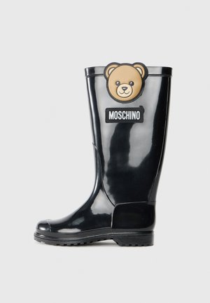 Black rubber rain boot with a textured surface, bear-shaped patch, and a visible Moschino label on the side. Lightweight and durable design.