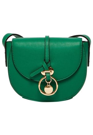 Groene leren crossbodytas met gebogen klep, gouden ring en hartvormige bedel detail aan de voorkant, en bijpassende groene band.