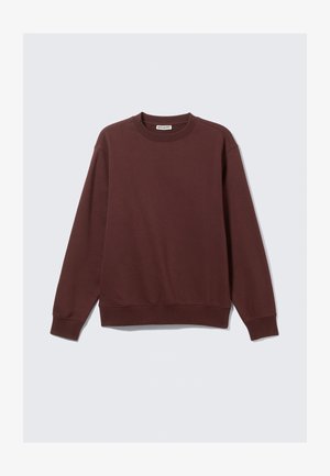 Mørkerød sweatshirt lavet af blødt stof, lange ærmer og rund halsudskæring. Har ribbede manchetter og kant. Brøndmærket er synligt indeni halsen.