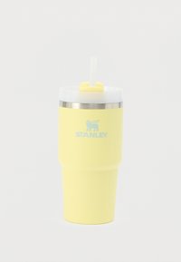 Gobelet isolant jaune avec un couvercle transparent, une paille et un accent en acier inoxydable. Fini extérieur lisse, avec le logo "STANLEY" en bleu.