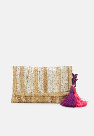 Sac clutch avec rayures en paille naturelle et argent métallique, bandoulière chaîne dorée, pompons roses et violets sur fond blanc.