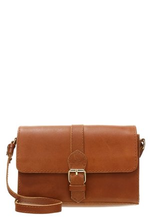 Ruskea nahkainen olkalaukku, jossa edessä solkikiinnitys ja säädettävä olkahihna valkoisella taustalla.