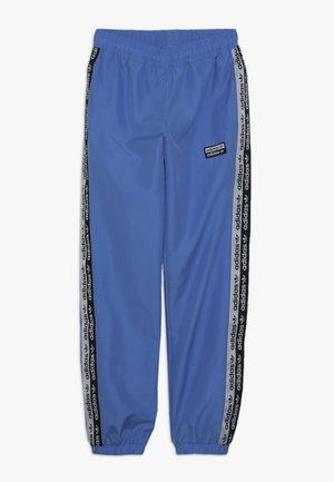 Niebieskie spodnie dresowe Adidas z czarnymi, markowymi paskami po bokach, elastyczną talią i mankietami przy kostkach.