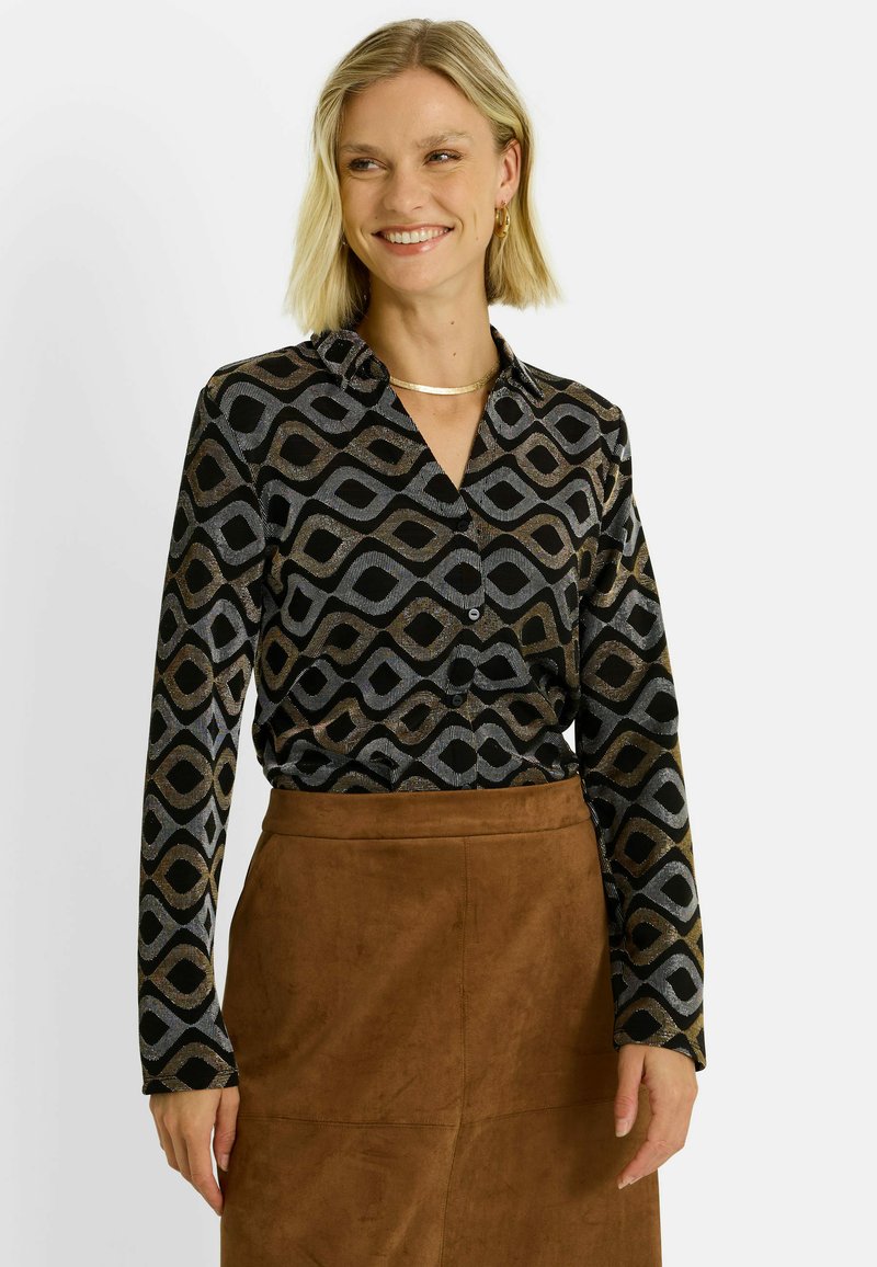 Chemisier à manches longues en noir avec un motif géométrique de vagues en argent et or. Il présente un devant à boutons et un col.