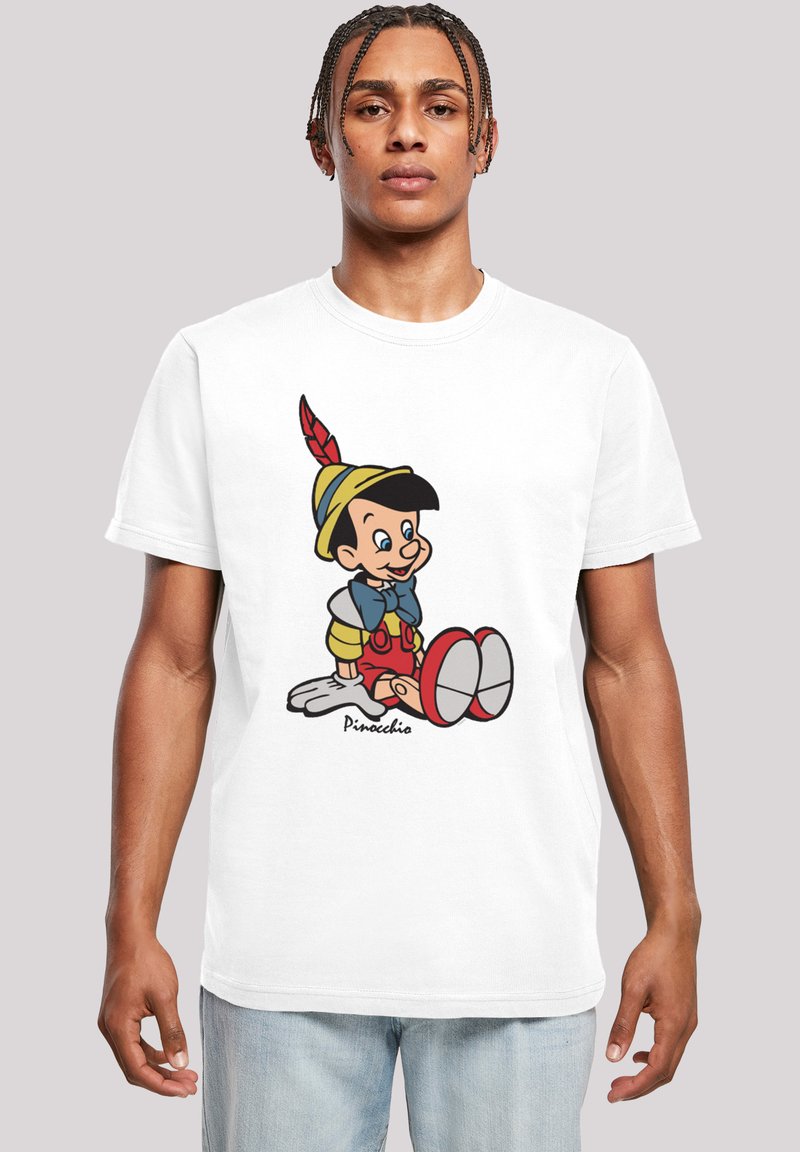 White cotton t-shirt featuring a colorful Pinocchio design with red overalls and a yellow hat, accented by a red feather and black shoes.