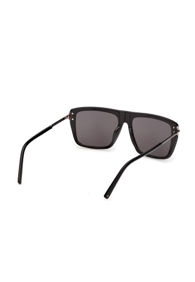 Gafas de sol negras de gran tamaño con forma cuadrada, lentes oscuras y varillas delgadas, mostradas desde un ángulo posterior sobre un fondo blanco.