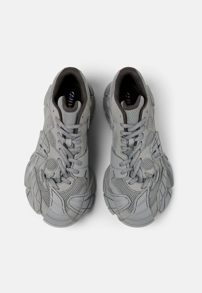 Gray sneakers with a textured mesh upper and rubber accents. Features laces, reinforced toe cap, and a bulky outer sole design.