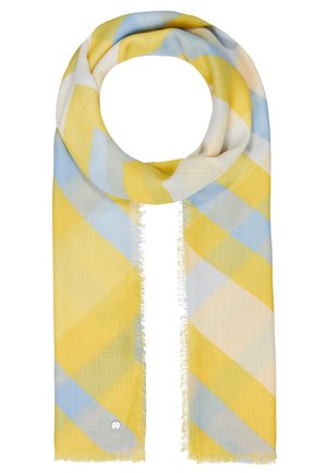 Leichter Schal mit diagonalem Karomuster in Gelb, Blau und Weiß, locker geschlungen mit Fransen an den Rändern und einer kleinen runden Metallplakette.