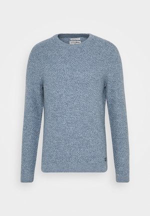 Pull tricoté bleu clair à col rond, manches longues, motif texturé et petite étiquette logo noire près de l'ourlet.