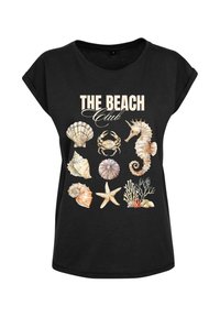 Musta t-paita, jossa on graafinen painatus simpukoista, ravusta, merihevosesta ja korallista, ja se on varustettu tekstillä "THE BEACH Club" vaalealla fontilla. Rennon tyylinen.