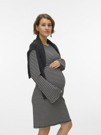 Εγκυμονούσα φορεμα σε ασπρόμαυρες ρίγες, με καμπανα μανίκια και στρογγυλεμένο σχήμα, συνδυασμένο με σκούρο γκρι ριχτάρι περασμένο στους ώμους.