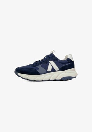 Scarpa da ginnastica blu navy con dettagli bianchi, suola bianca spessa, chiusura con lacci e linguetta sul tallone, mostrata di profilo sinistro.
