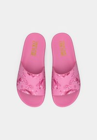 Șlapi roz cu model floral și designuri detaliate pe bareta, cu tălpi texturate pentru aderență. Numele mărcii este imprimat cu aur.