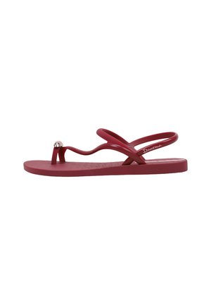 Sandale plate rouge avec des brides ondulées, accent argenté sur la lanière entre les orteils et bride au talon pour le maintien, conçue pour un usage décontracté.