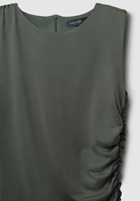 Dunkelgrüne ärmellose Bluse mit gerüschtem Detail auf der rechten Seite und einem Reißverschluss auf der Rückseite.