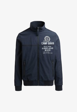 Marineblaue Jacke mit hohem Kragen, Reißverschluss vorne, zwei Seitentaschen und weißen grafischen Textdetails. Hergestellt aus einem glatten, langlebigen Stoff.