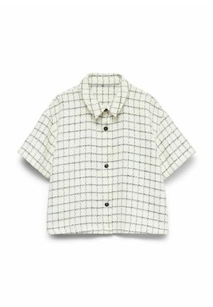 Chemise à manches courtes, boutonnée, en tissu texturé ivoire avec un motif à carreaux noirs. Elle présente un col classique et une fermeture à boutons sur le devant.