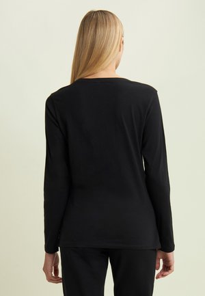 Maglietta nera a maniche lunghe con scollatura rotonda e una trama liscia e morbida. Vista posteriore, design attillato che si estende fino ai fianchi.