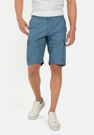Lyseblå cargo shorts med sidelommer og flad front, lavet af letvægtsstof, parret med hvide sneakers.