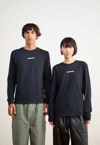 Salomon LOGO TEE UNISEX - T-shirt estampada - deep black