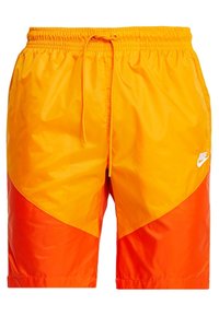 Žluté a oranžové plavkové šortky s síťovanou texturou, elastickým pasem a stahovací šňůrkou. Na levé dolní straně je bílý Nike logo.