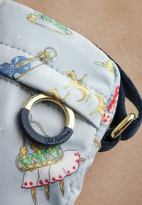 Mönstrad tygväska i ljusgrå färg med färgglada illustrationer av djur och figurer. Inkluderar en ringdetalj i guld och marinblå.