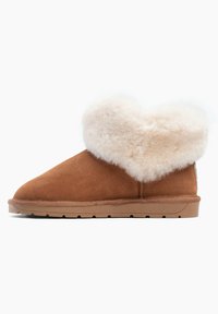 Botas de tobillo de ante marrón con un suave puño de piel sintética crema. Suela plana con goma texturizada, diseño de punta redondeada y detalles de costura simples.