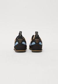 Schwarze und blaue Kletterschuhe mit einem Obermaterial aus Wildleder, Netzeinsätzen und Gummisohlen. Mit Fersen-Schlaufen und Belüftungsöffnungen.