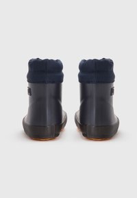 Vanntette marine gummistøvler med en teksturert svart såle, med en samlet stoffkrave på toppen. Bakfra vises logodetaljer.
